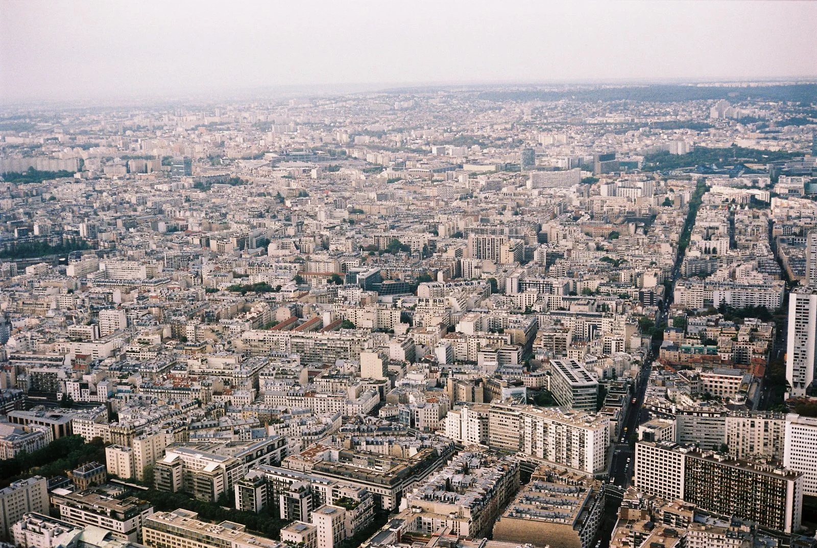 Expansive aerial view of Paris displaying dense urban architecture and skyline from above.