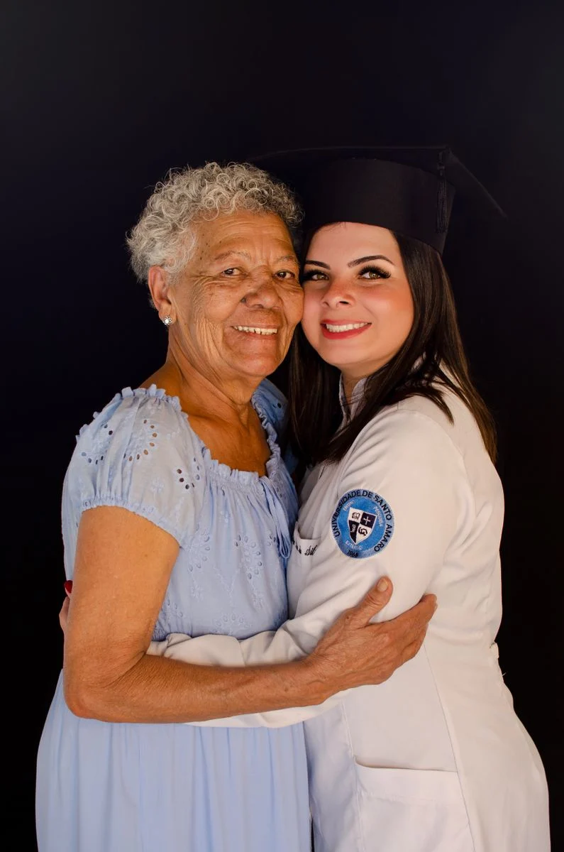 Mutuelle Sante Senior : Joyful portrait of a graduate embracing her mother or grandmother. Smiling and proud.