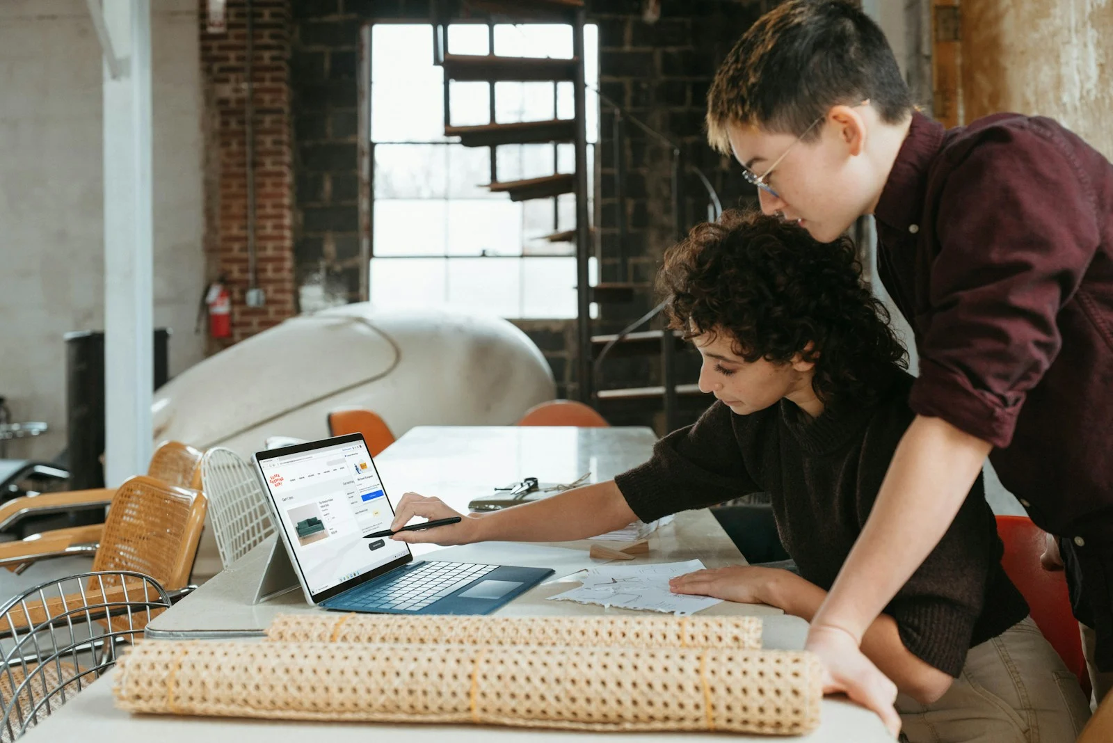 TNS : a man and a woman are looking at a laptop