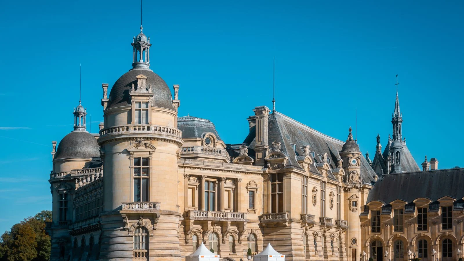 mutuelle santé Elegant Château de Chantilly showcasing classic French architecture against a vibrant blue sky.