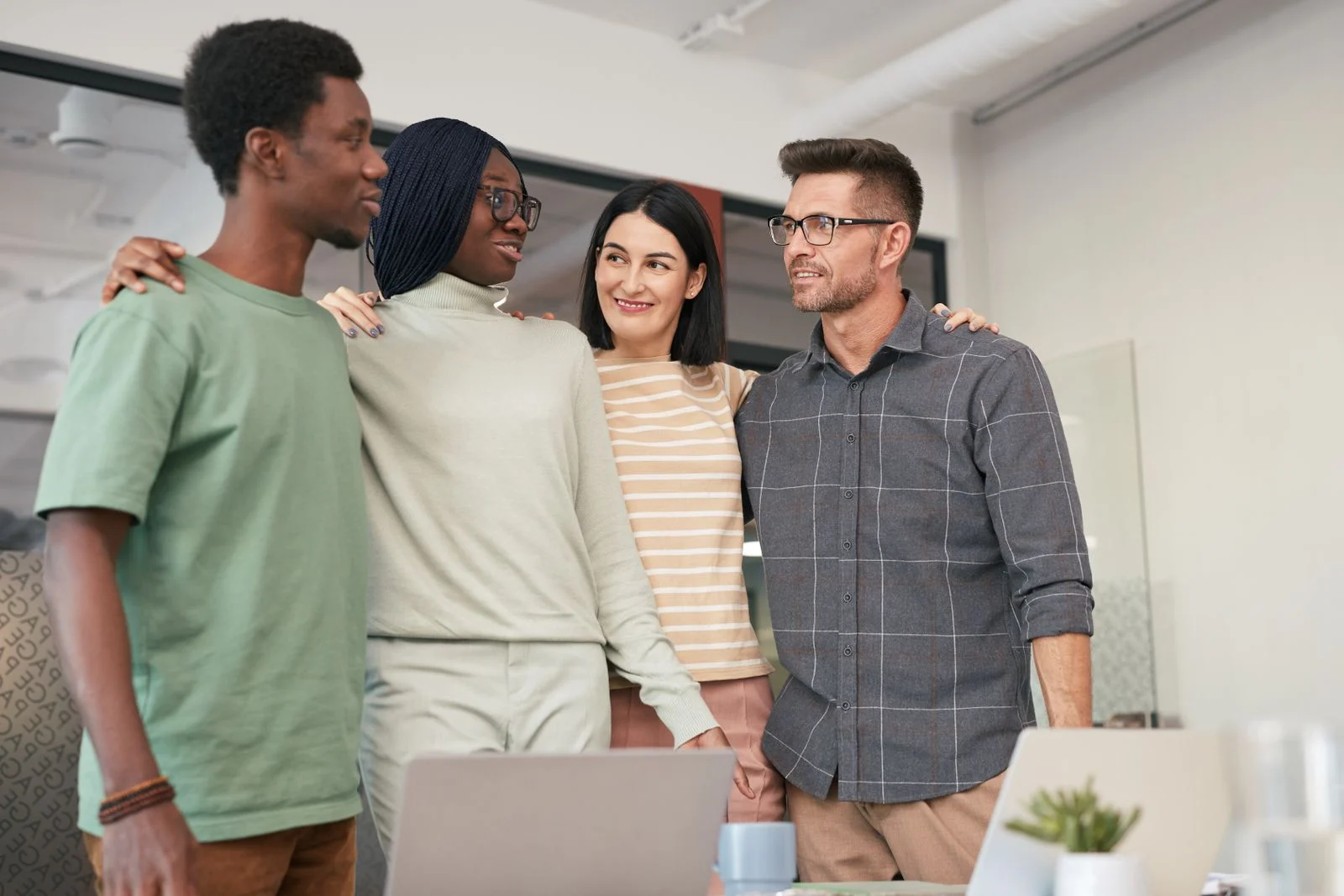 Mutuelle Entreprise Collective : Four diverse colleagues sharing a moment of teamwork and collaboration in an office setting.