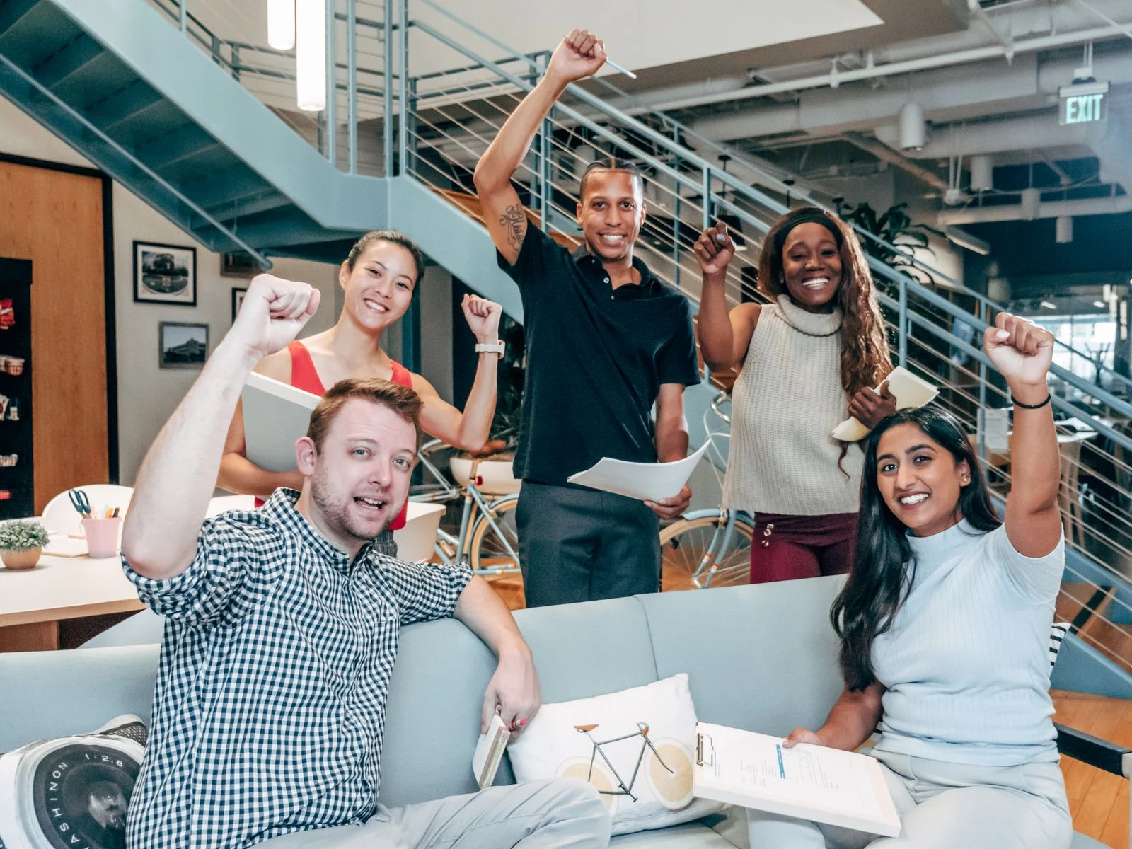 Mutuelle Entreprise Collective : A diverse group of coworkers cheerfully celebrating success in a modern office setting.