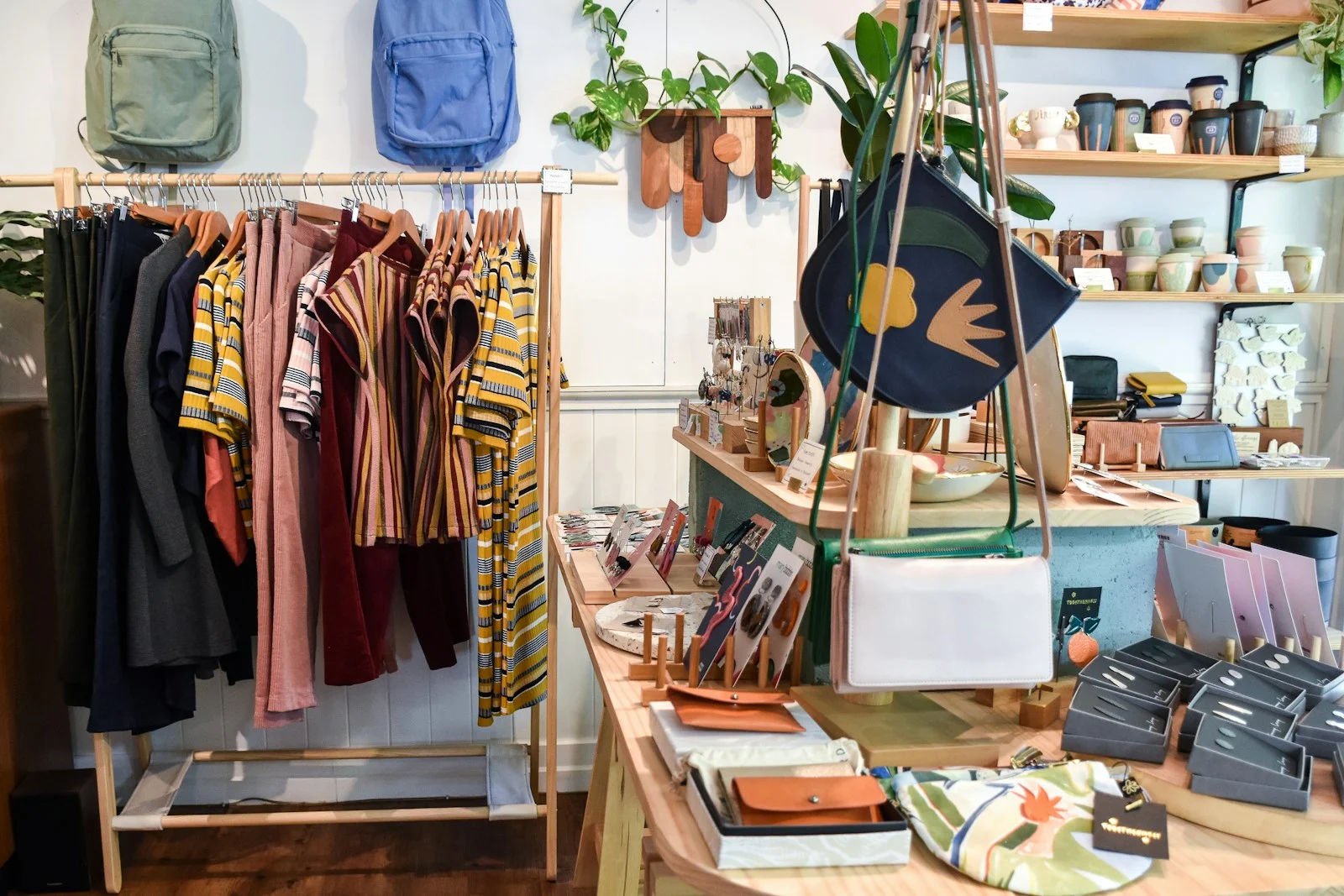 TNS : assorted-colored clothes on rack near brown wooden table