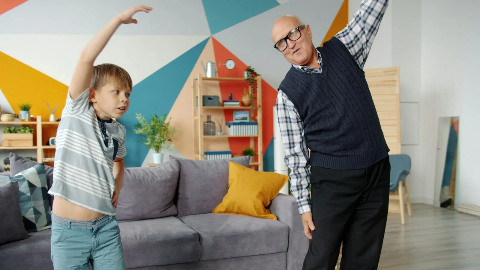 Mutuelle Sante Senior : Grandfather and grandson exercising together indoors