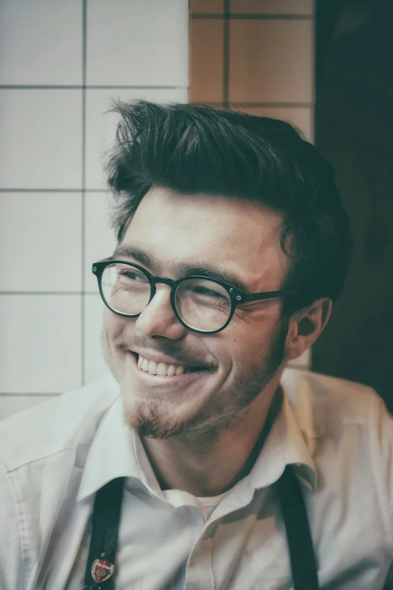 Mutuelle Individuelle : photo of man wearing black-framed eyeglasses beside wall tile