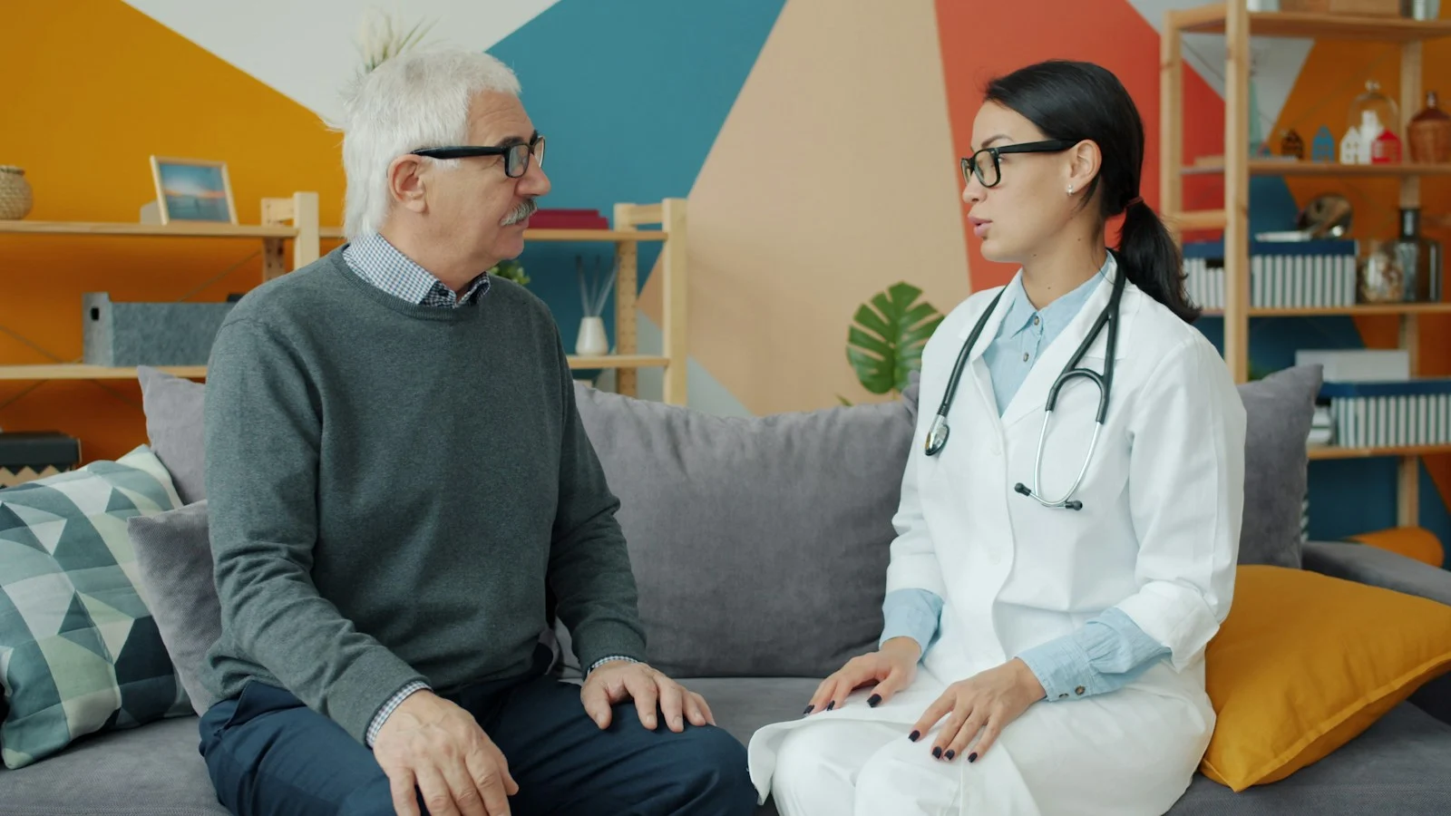 Mutuelle Sante Senior : Doctor talks with an elderly patient on a couch