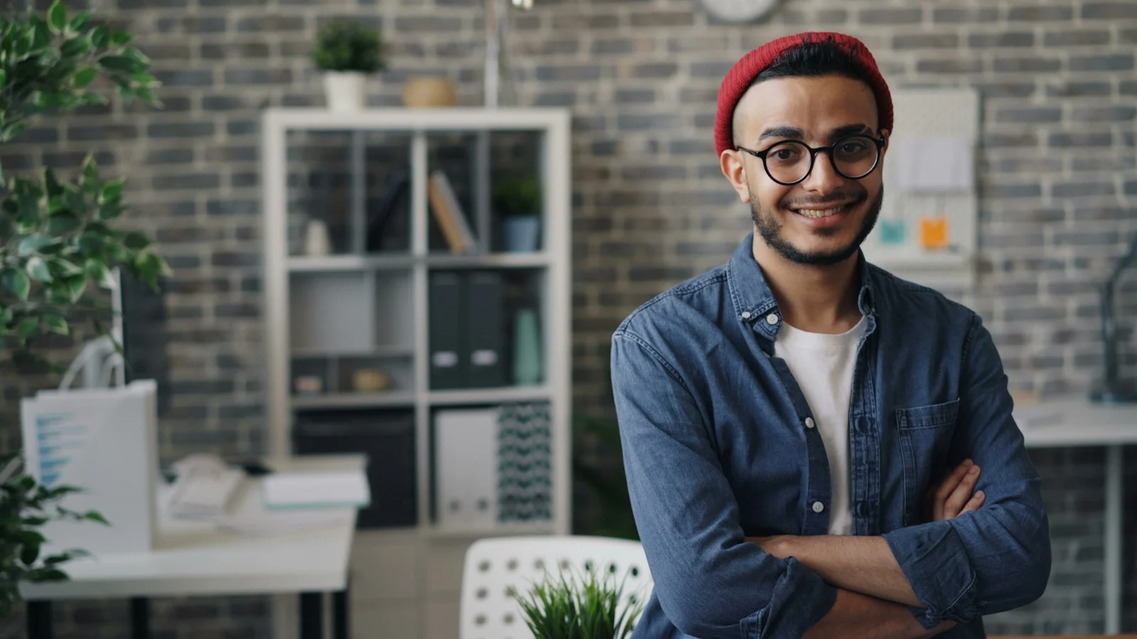Mutuelle Individuelle : a man with glasses and a red hat standing in an office