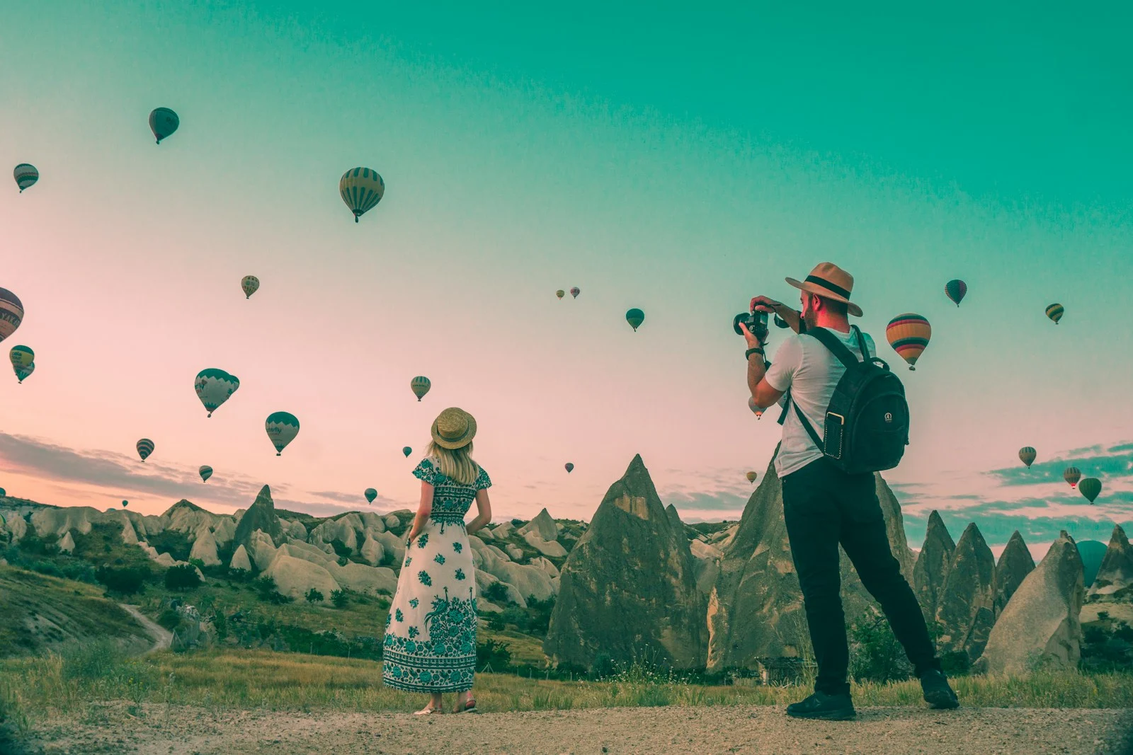 Expatrie : A woman and a man photographing hot air balloons over Cappadocia, Turkey