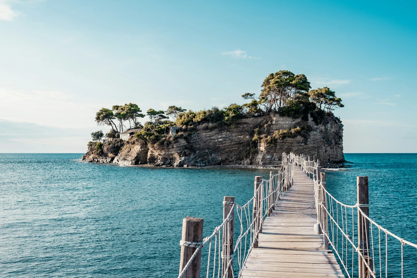 Expatrie : brown wooden bridge over blue sea under blue sky during daytime