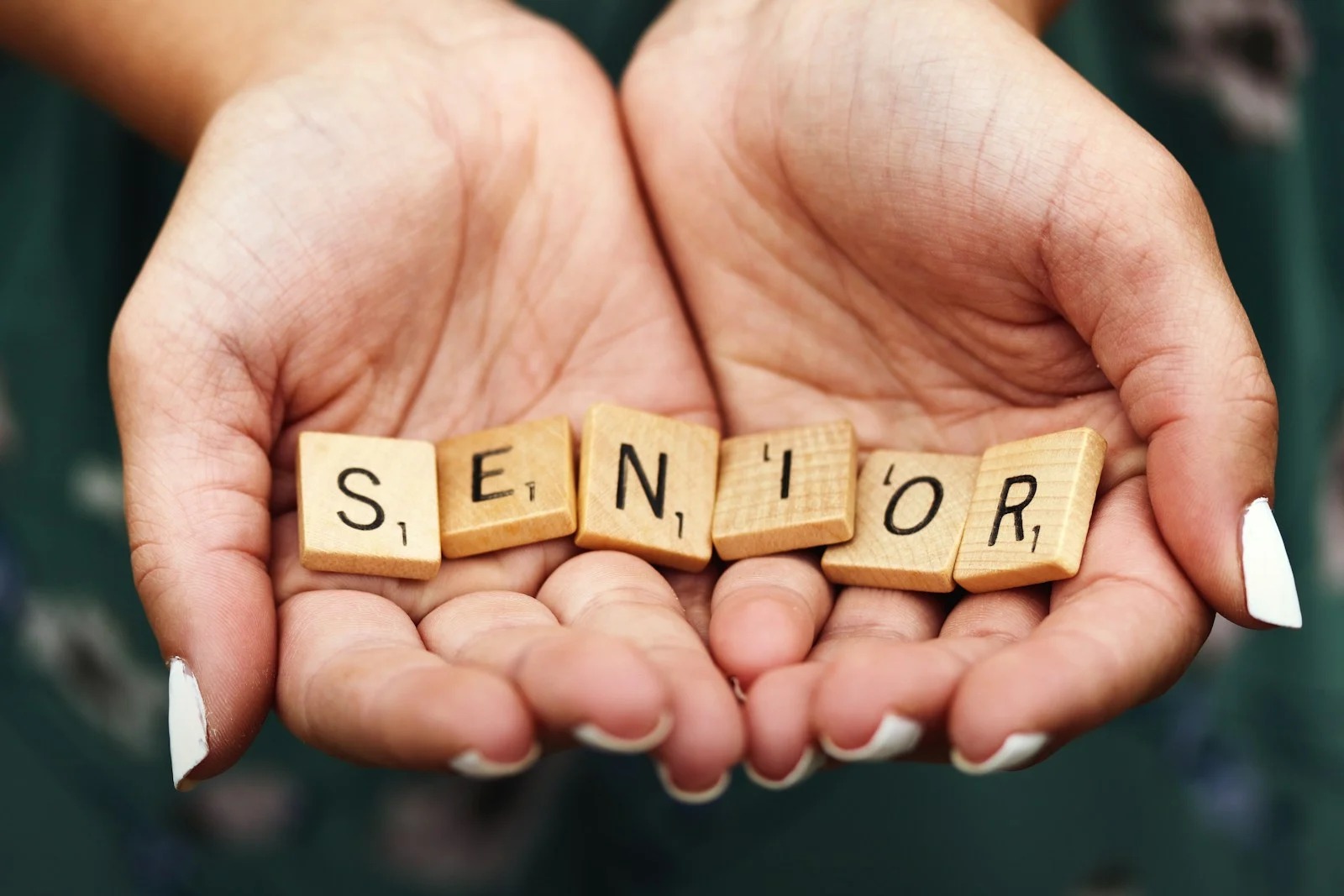 Photo by Jen Theodore Comparateur mutuelle santé Senior dice on person's palm