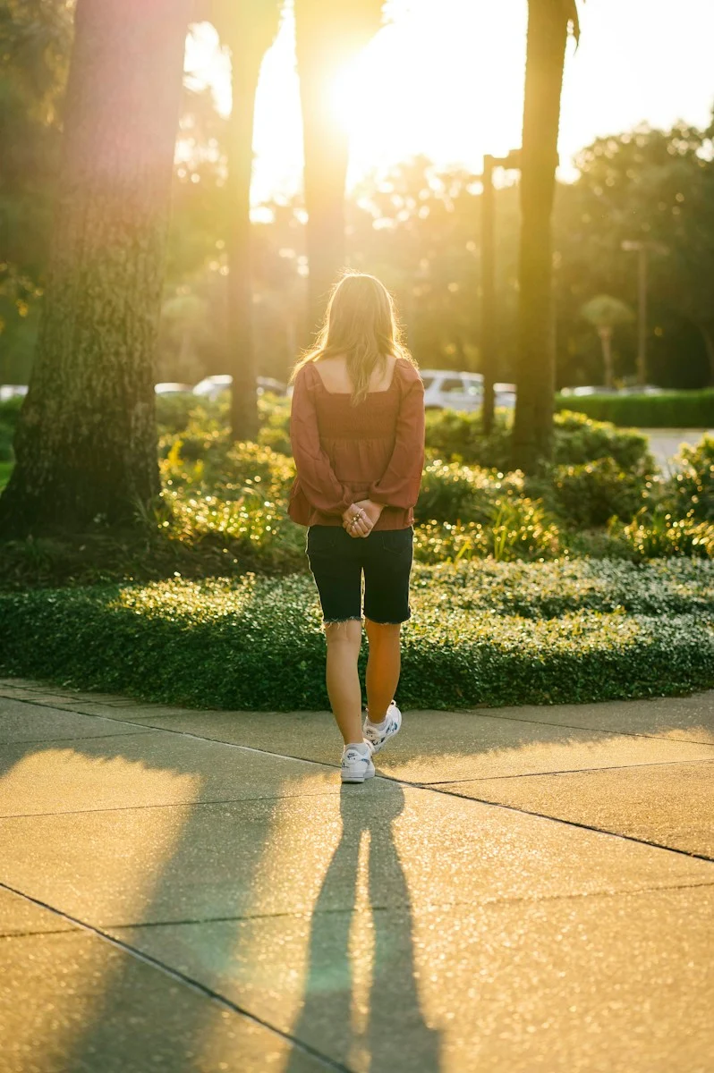 Mutuelle Individuelle : a woman walking down a sidewalk in a park