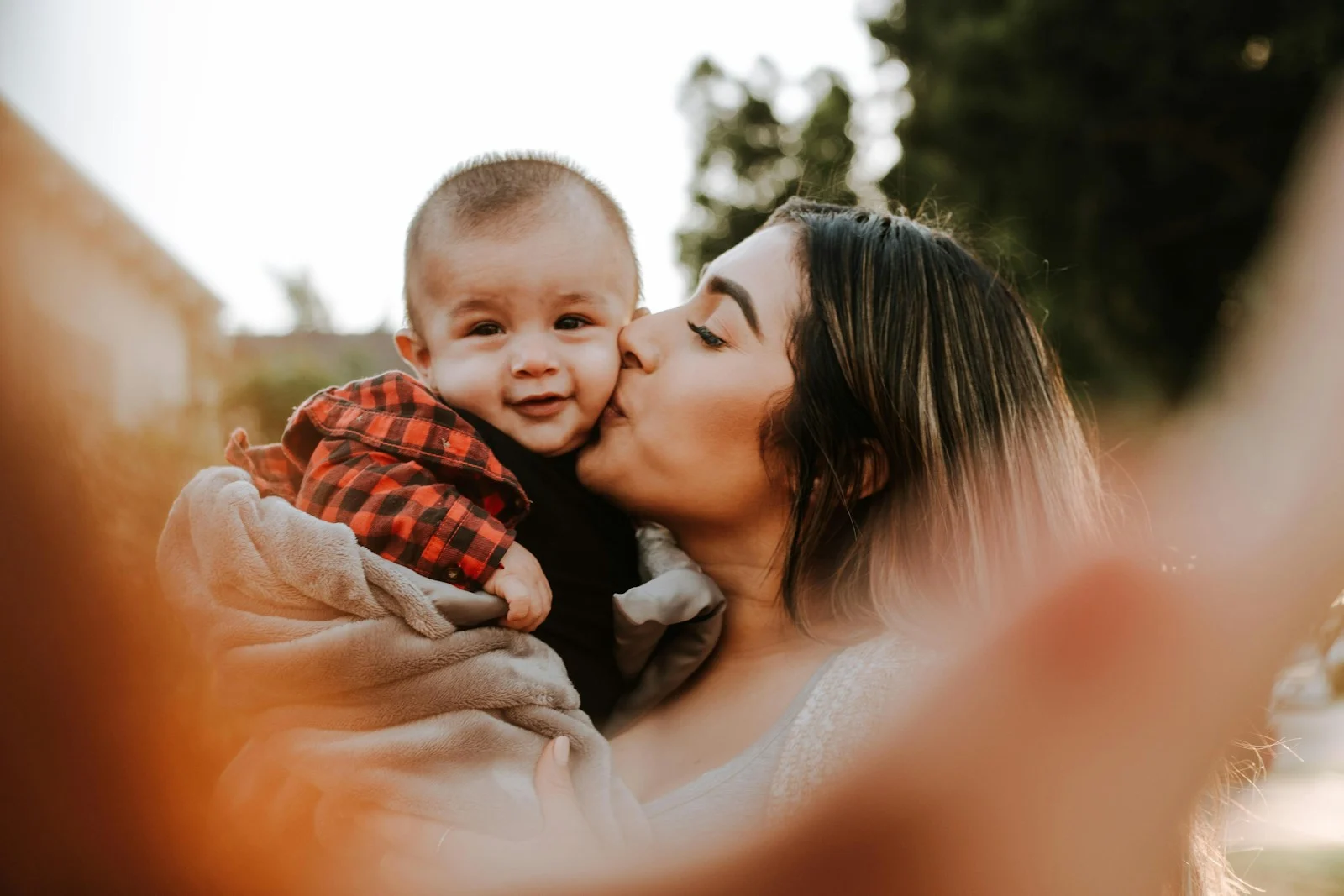 Family woman kiss a baby while taking picture