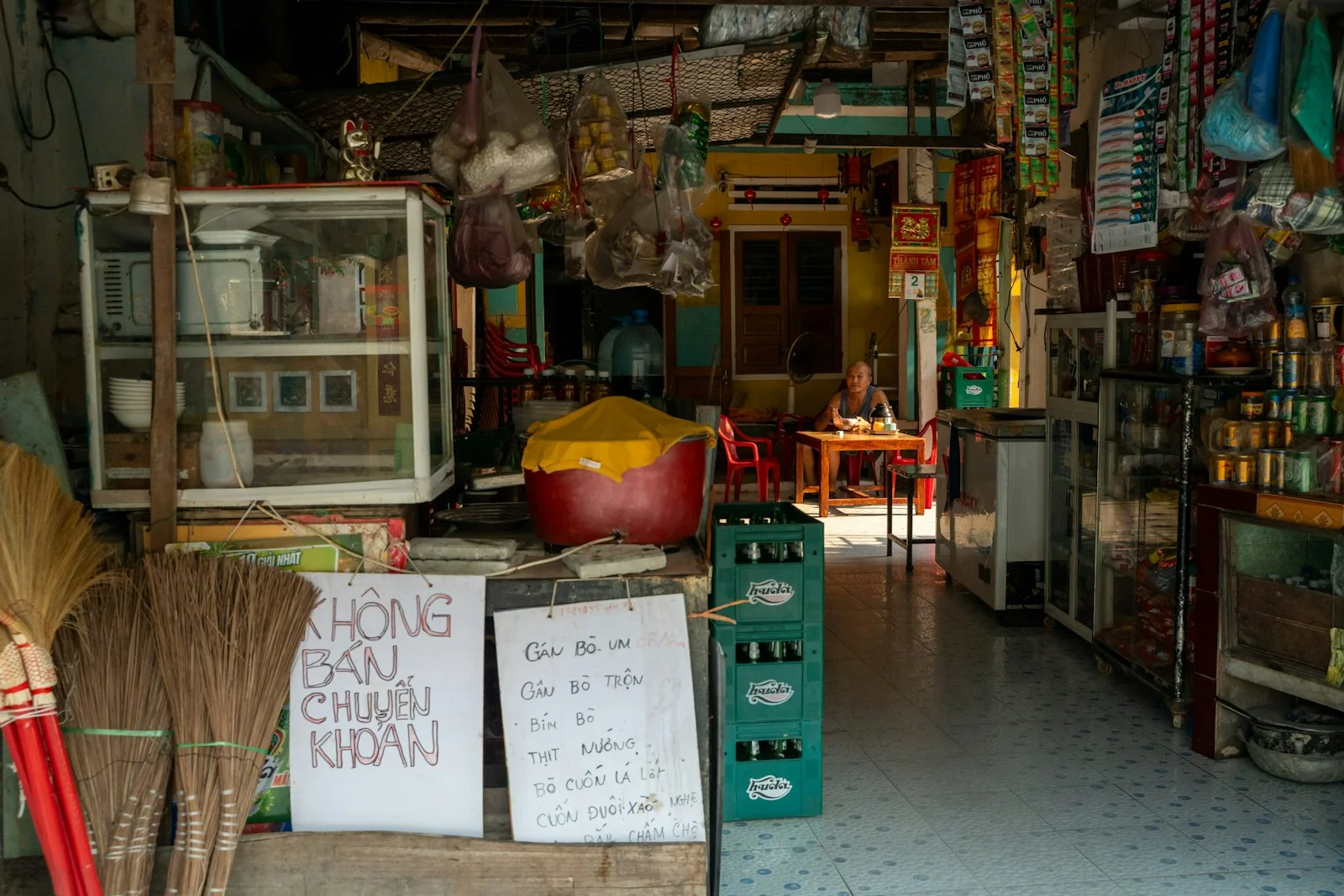 TNS : A cluttered storefront with goods and signs visible signage