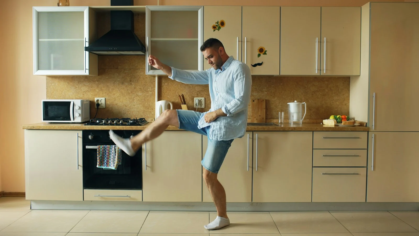 Mutuelle Individuelle : Man dancing energetically in a modern kitchen
