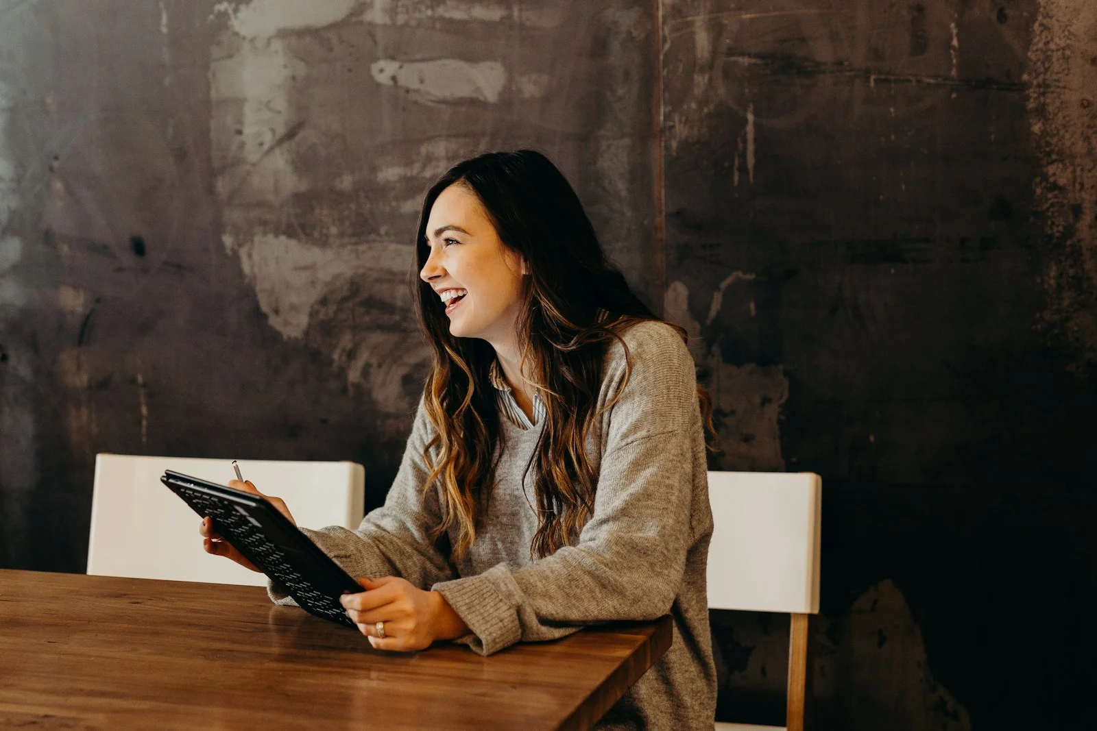 TNS : woman sitting around table holding tablet