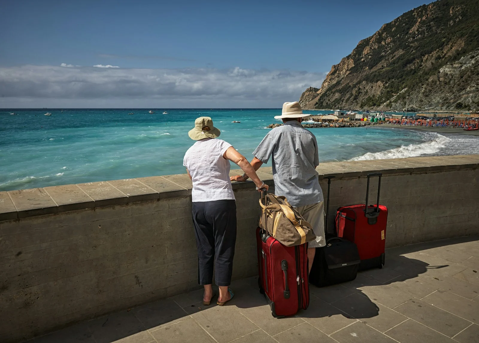 Expatrie : man and woman standing beside concrete seawall looking at beach