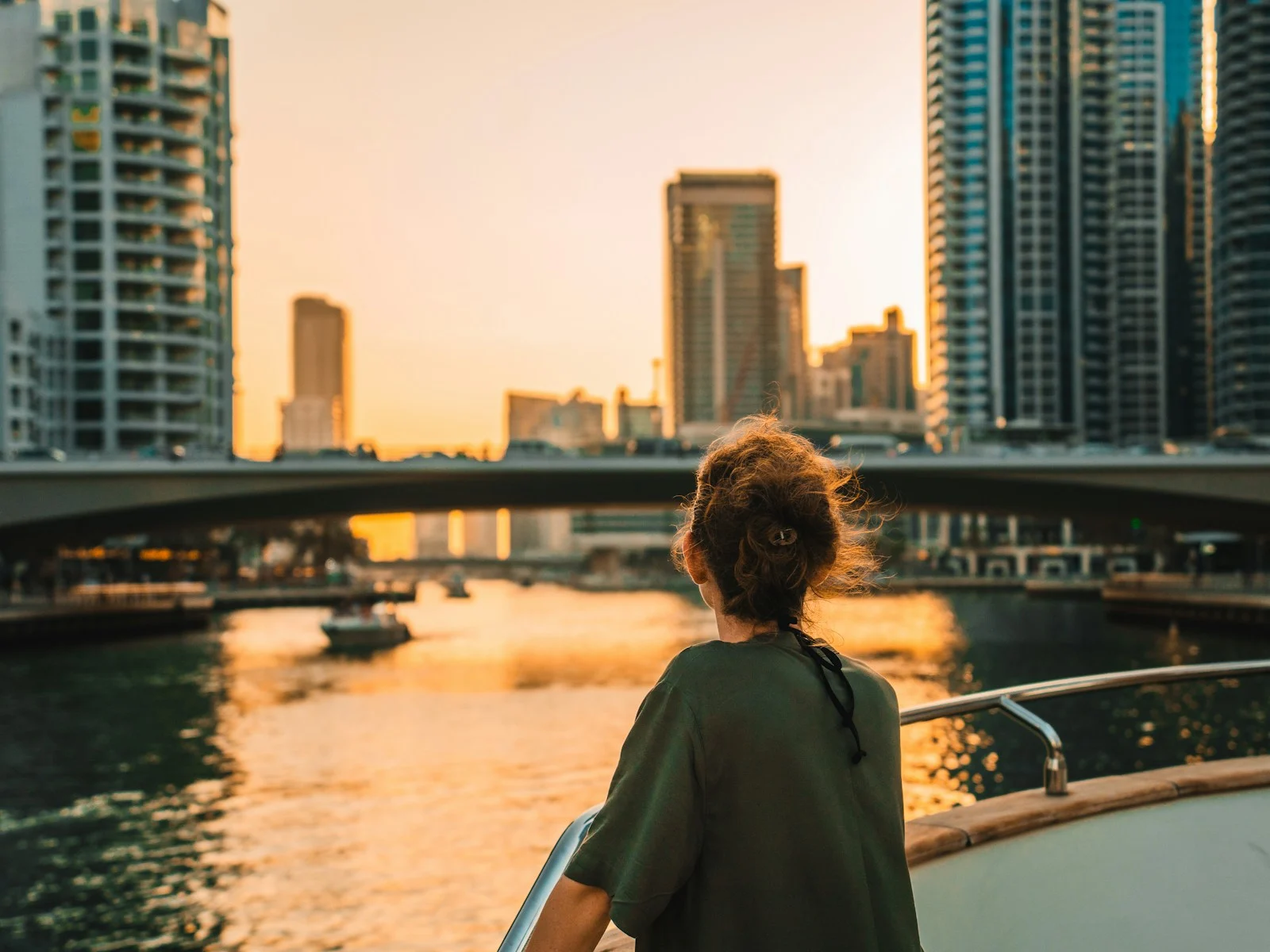 Expatrie : Woman on boat overlooking city skyline at sunset