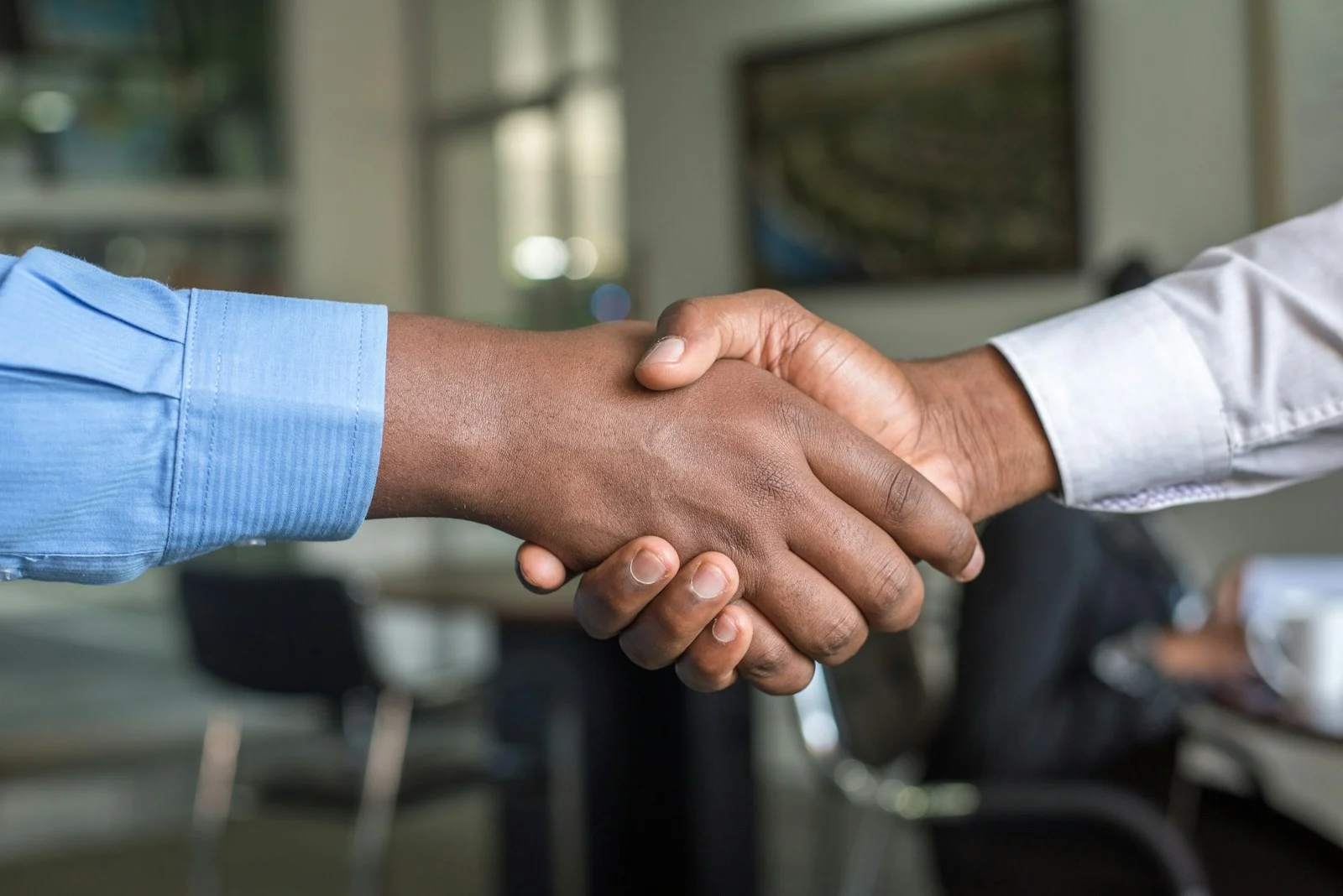 Deux personnes se serrant la main, symbolisant un accord mutuelle premier salarié
