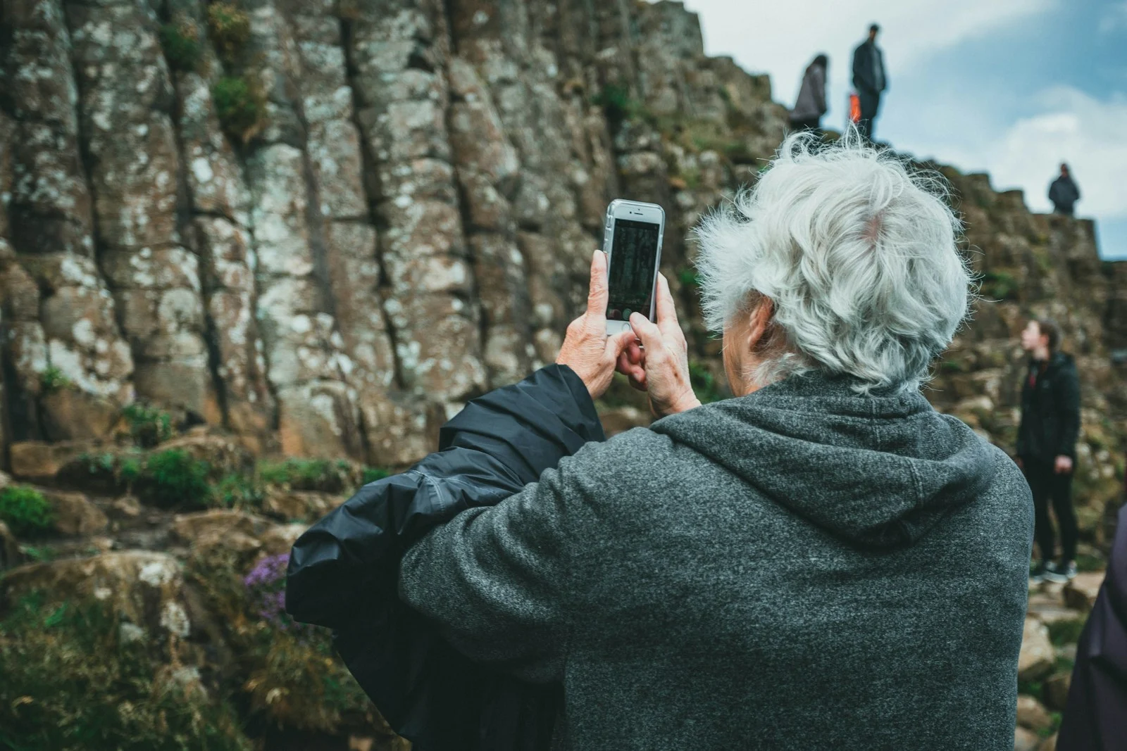 Mutuelle Sante Senior : man in black hoodie holding smartphone