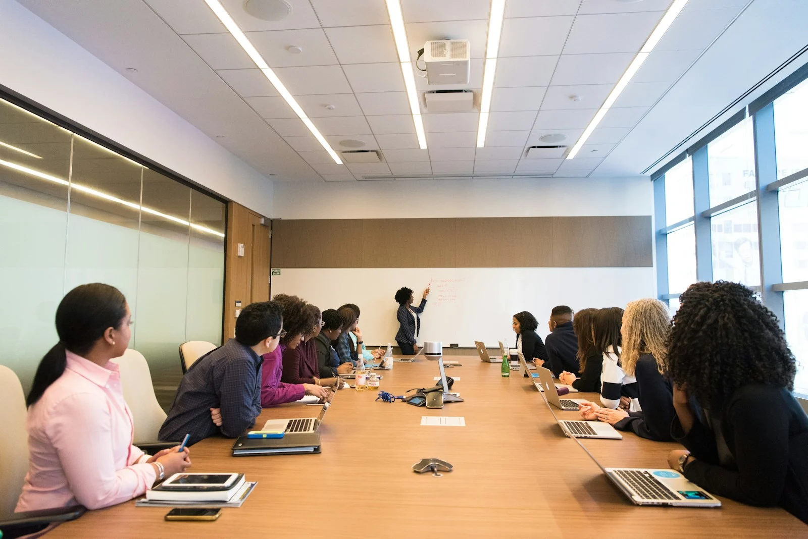 Mutuelle Entreprise Collective : people on conference table looking at talking woman