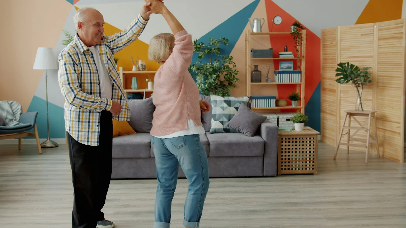 Mutuelle Sante Senior : Elderly couple dancing joyfully in a living room