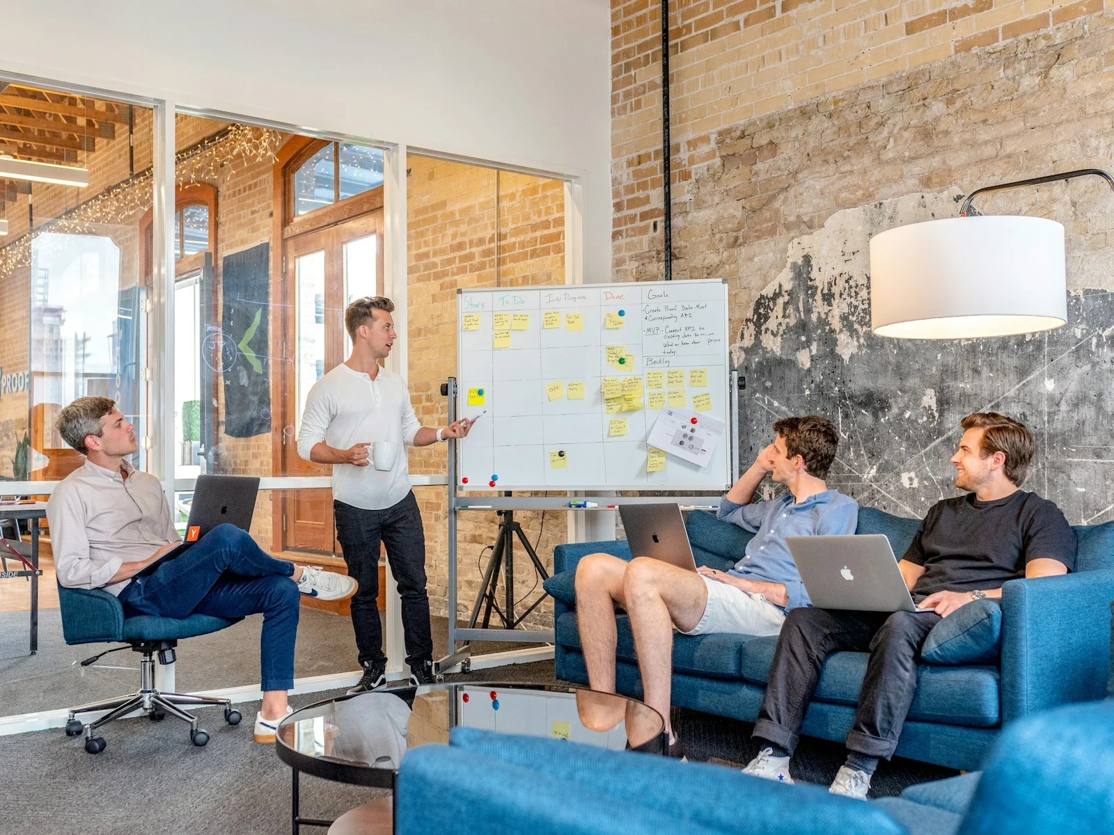 tMutuelle Entreprise Collective : hree men sitting while using laptops and watching man beside whiteboard