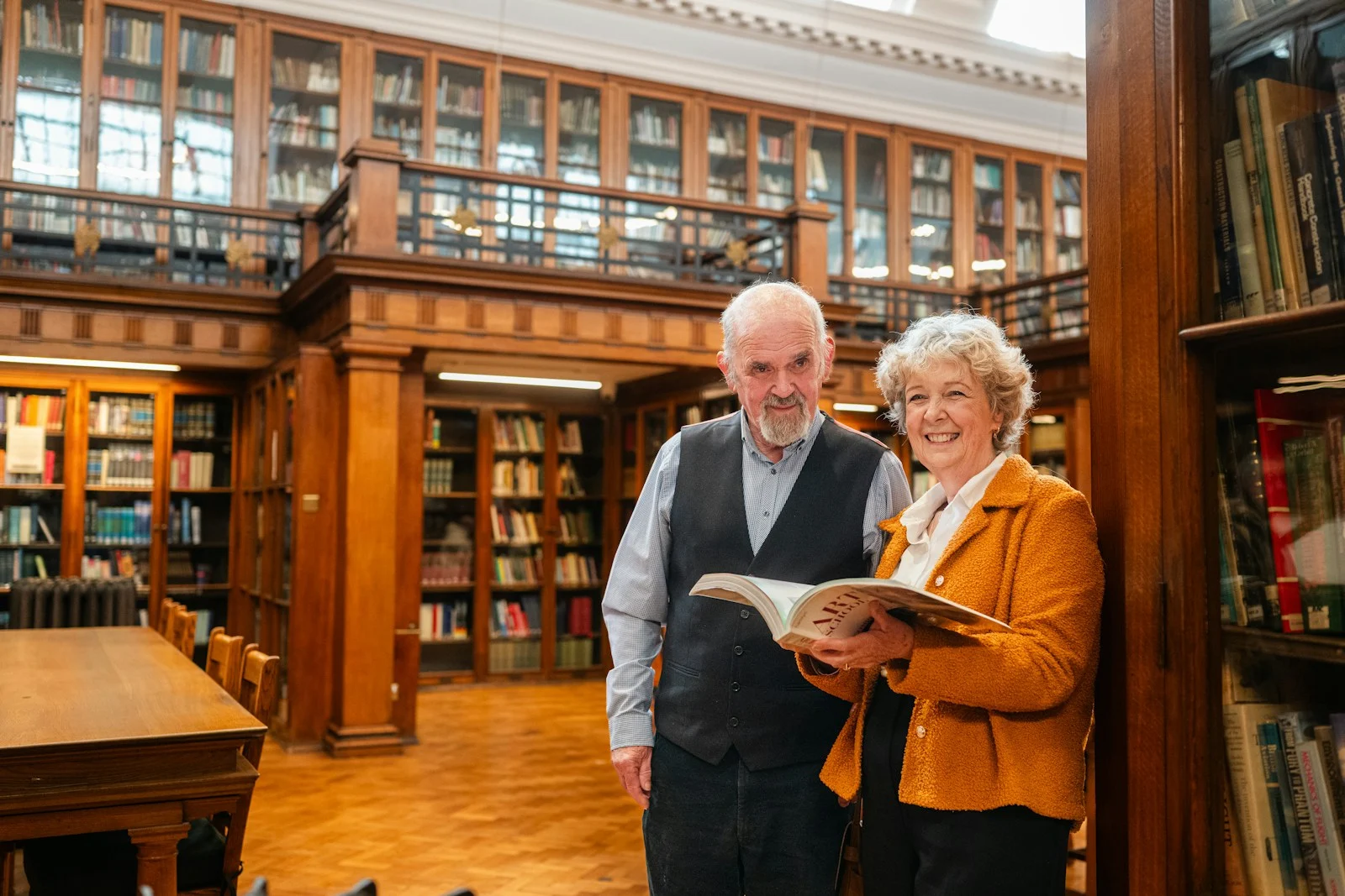 Mutuelle Sante Senior : Elderly couple holding a book in a library